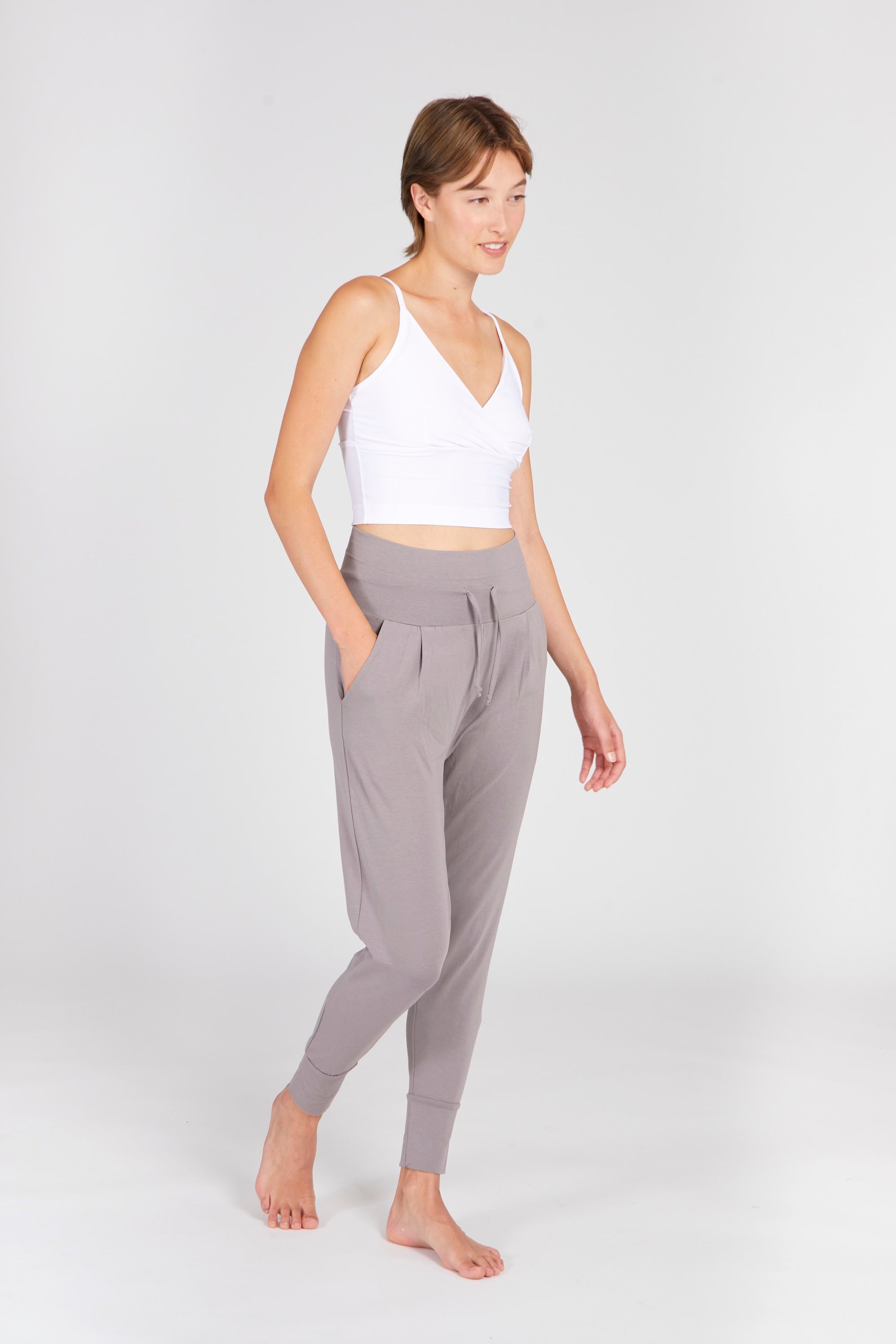 Model trägt Cosy Pants Pebble im Relaxed Tapered Fit kombiniert mit Lux Bra white – Outfit-Ansicht