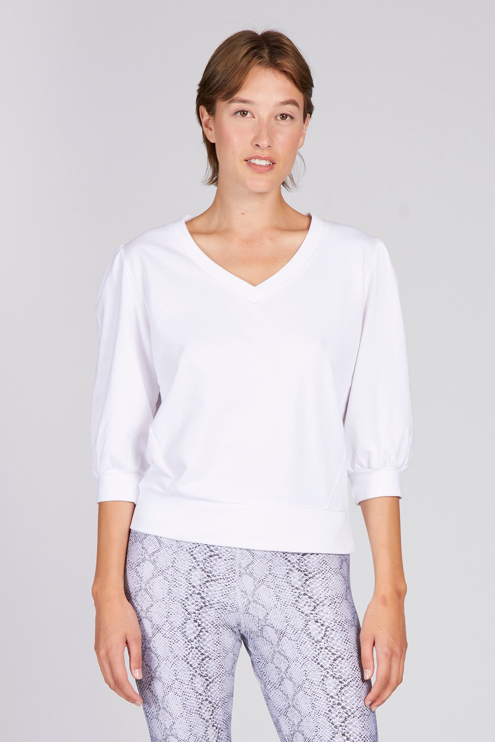 Model trägt weißen Sweater Chic mit V-Ausschnitt und 3/4 Ärmeln in relaxed Fit kombiniert mit der Lux Leggings