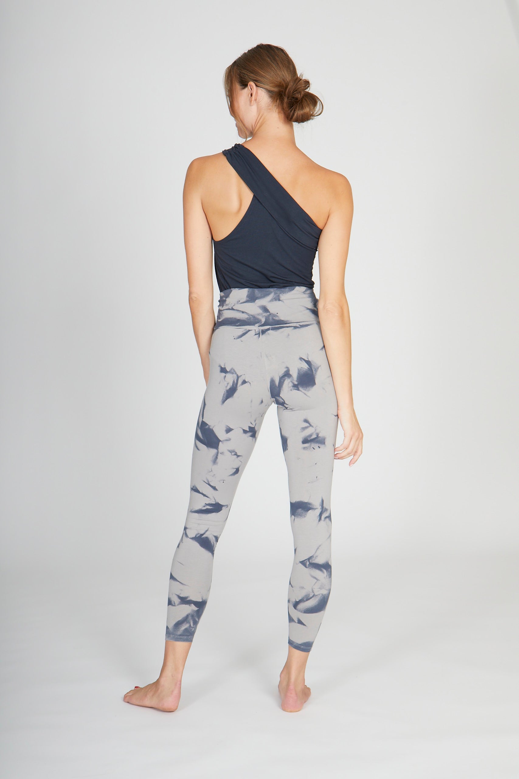 Model trägt Leggings stone-batik und One Shoulder Top anthracite